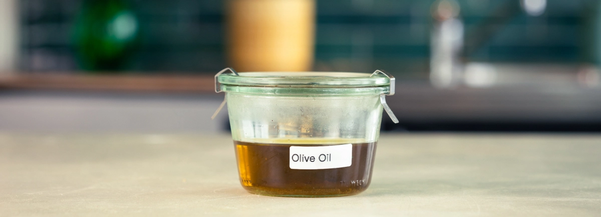 Conservazione dell’olio d’oliva infuso con cannabis Contenitore di vetro con olio d’oliva infuso con cannabis, etichettato e pronto per la conservazione.