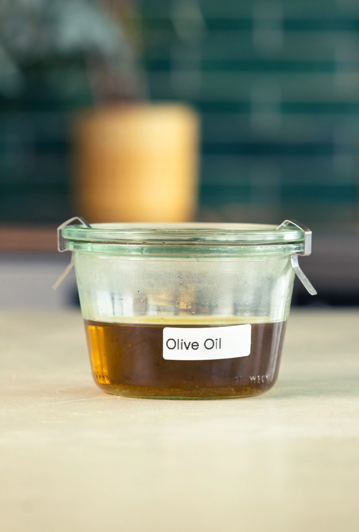 Conservazione dell’olio d’oliva infuso con cannabis Contenitore di vetro con olio d’oliva infuso con cannabis, etichettato e pronto per la conservazione.