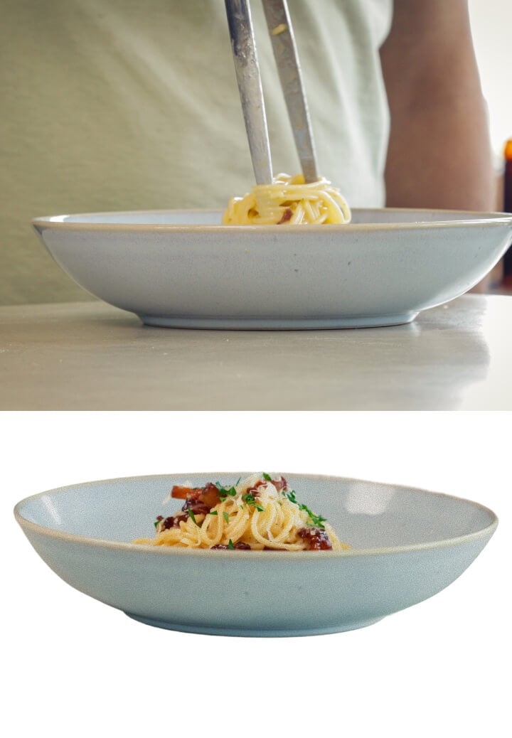 Impiattamento di spaghetti alla carbonara cremosa infusa alla cannabis con pancetta e formaggio grattugiato, ultimo passo prima di servire